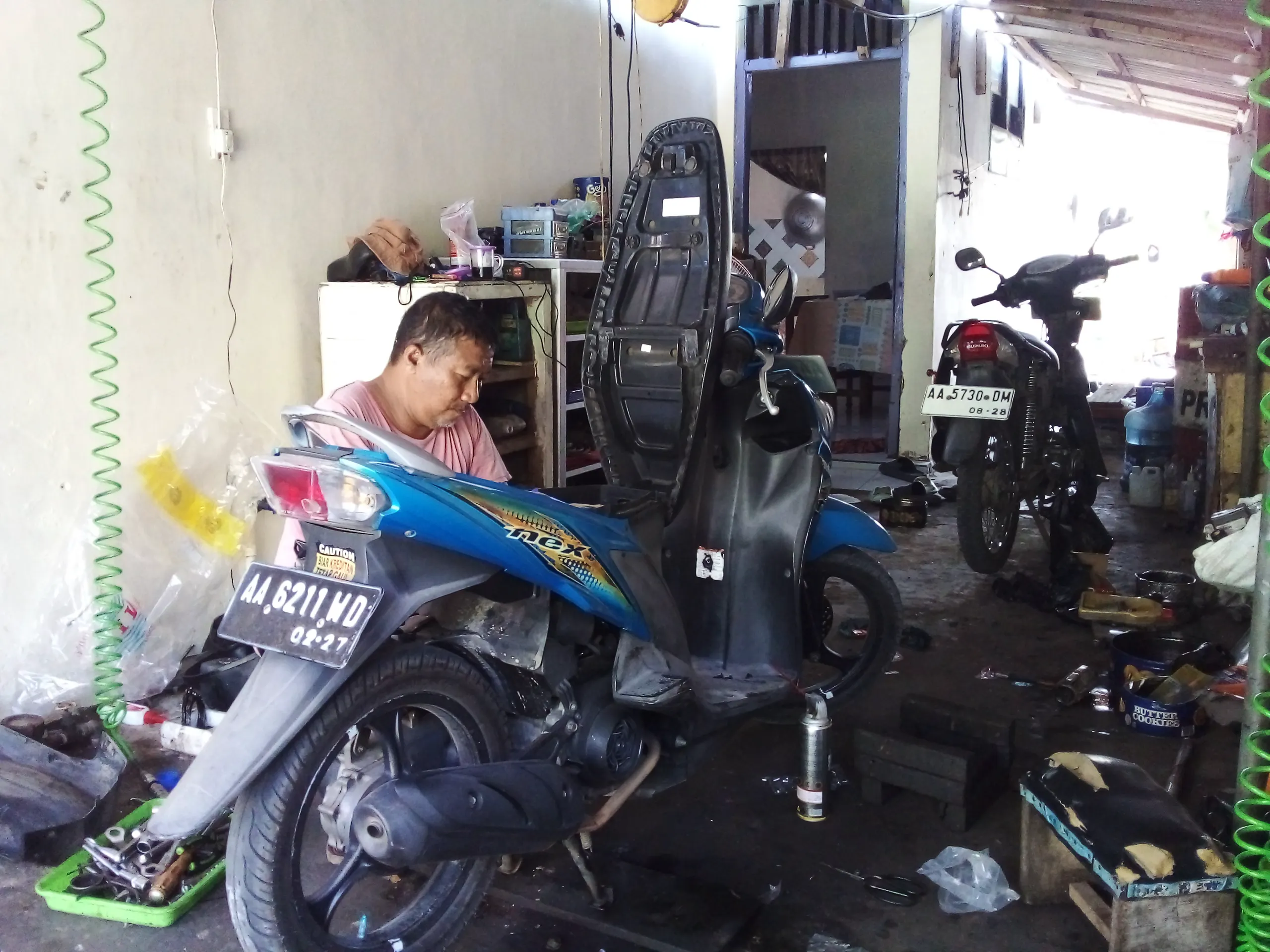 Mekanik memperbaiki sepeda motor di bengkel